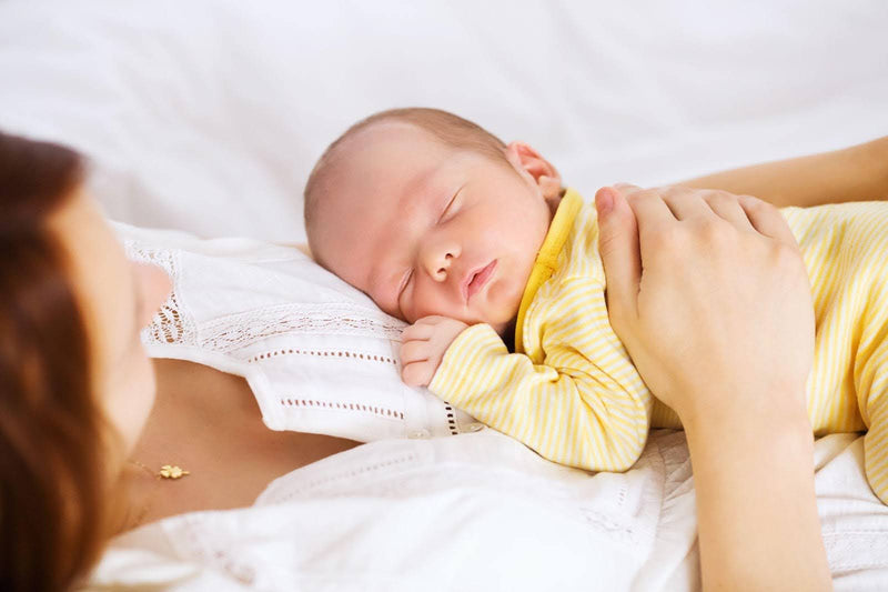 A woman holds a baby close to her chest embodying warmth and nurturing in a loving embrace