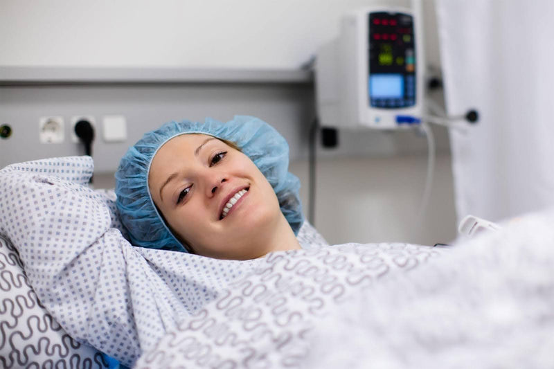 A woman in a hospital bed smiling warmly suggesting a moment of joy and recovery