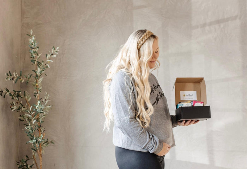 pregnant mom holding a gift box set