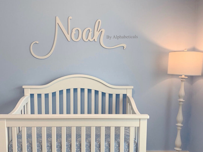 minimalist room with noah's name and lampshade in white and crib  