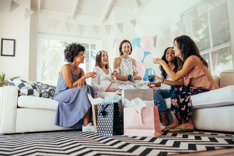 Group of women celebrating a baby shower in a living room.