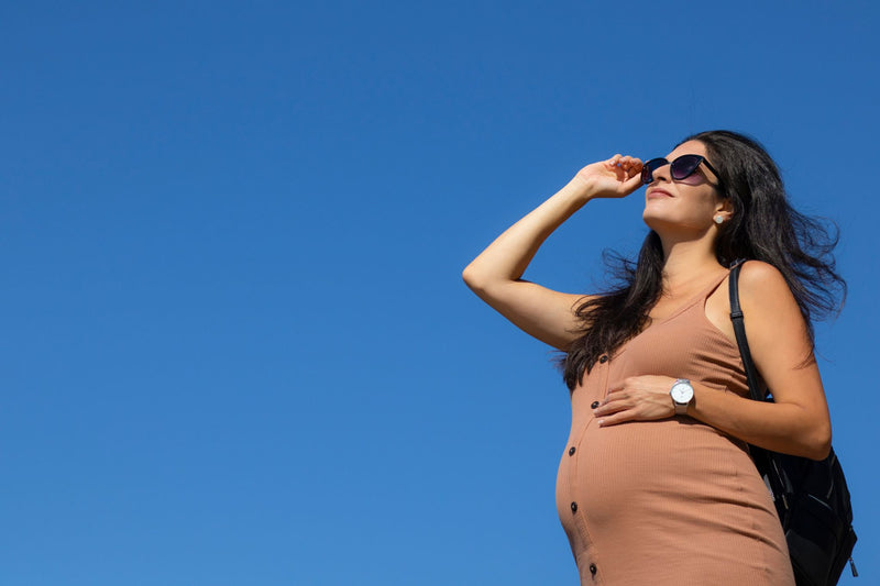 Woman in a brown dress against a clear blue sky