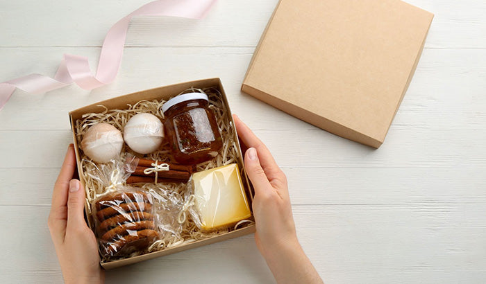 Womans hands holding a box with cookies and other items new mom care package momma care package care package for mom.